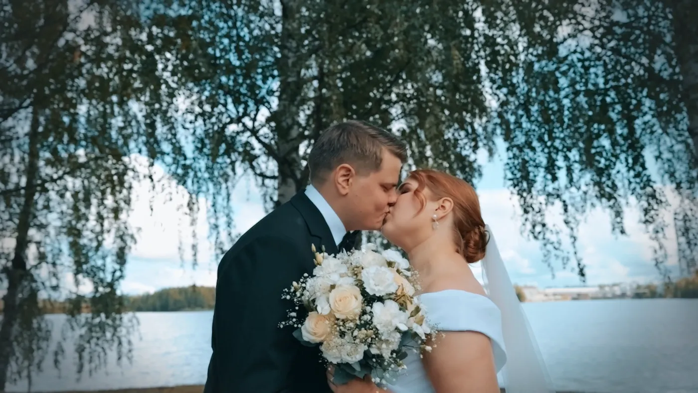 Hääparin suudelma koivun alla järven rannalla